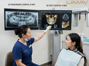 Dentist demonstrating 2D panoramic vs 3D CBCT dental X-ray scans to a patient on dual monitors.