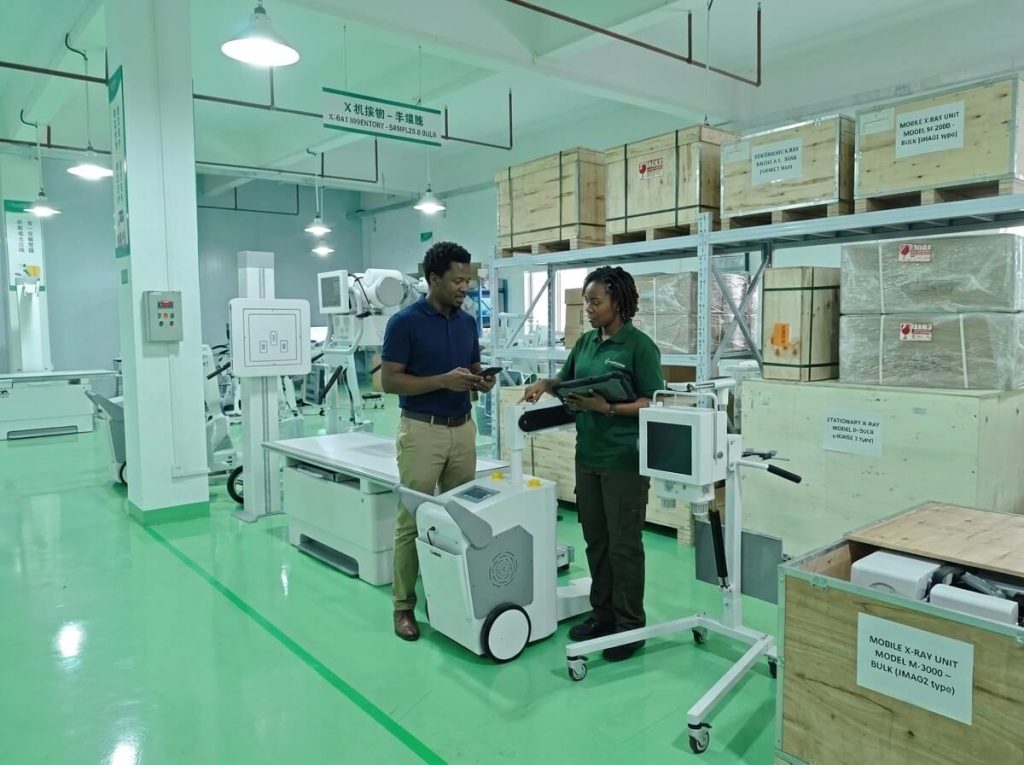 Mobile X-Ray Machine Factory Inspection Medical equipment specialists inspecting mobile X-ray unit inventory in factory warehouse.