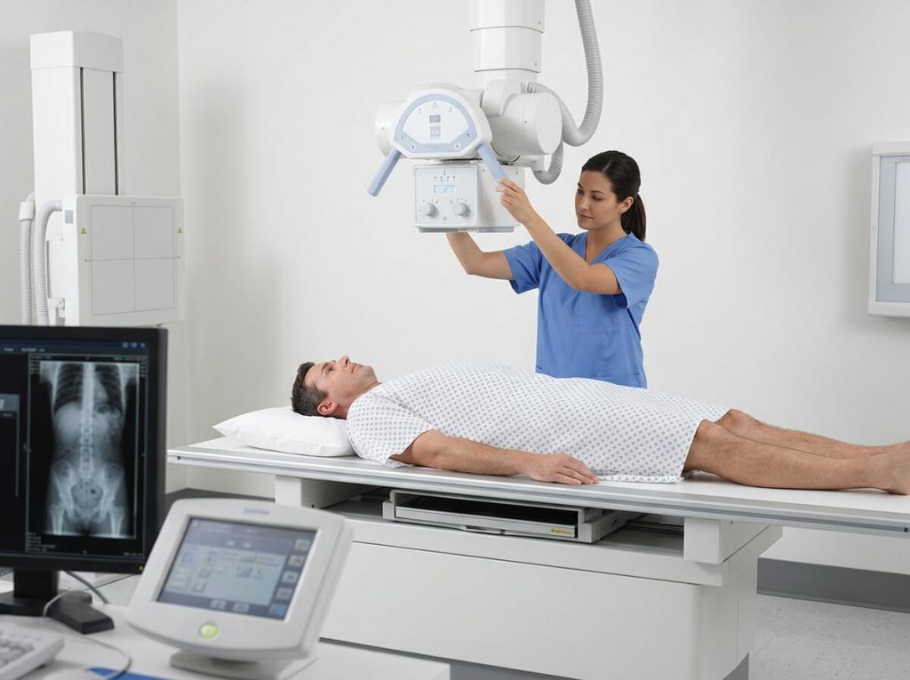 Radiographer preparing patient for chest and abdominal examination with overhead X-ray tube.